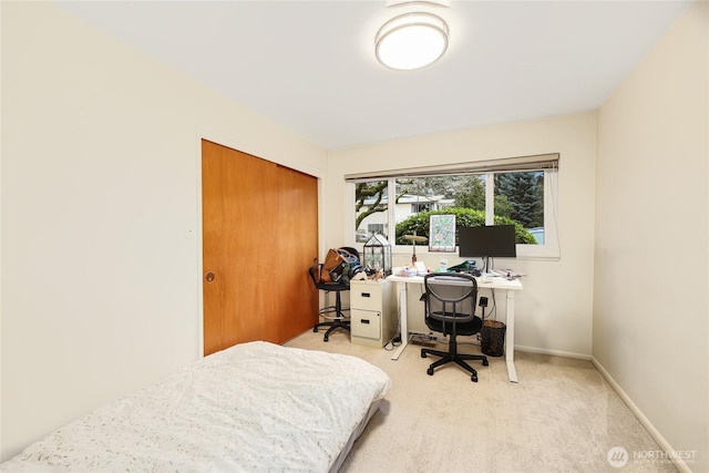 carpeted bedroom featuring baseboards and a closet