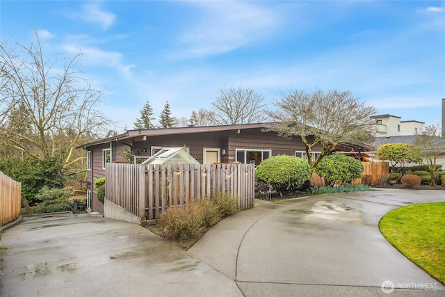 view of front of property featuring driveway and a fenced front yard