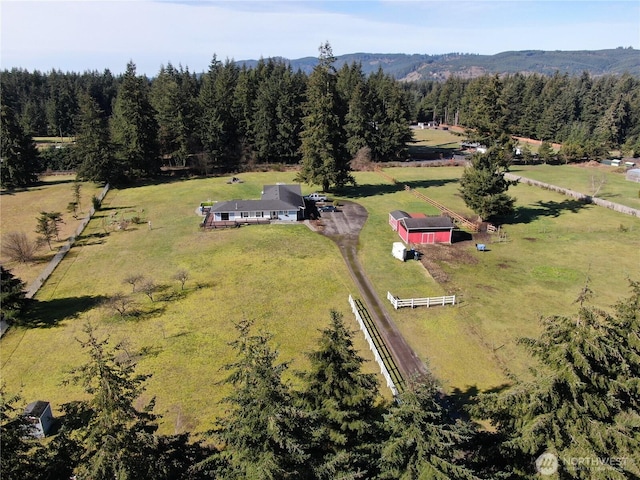 drone / aerial view featuring a view of trees and a rural view