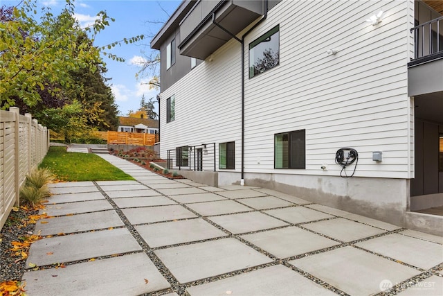 rear view of house featuring a patio and fence