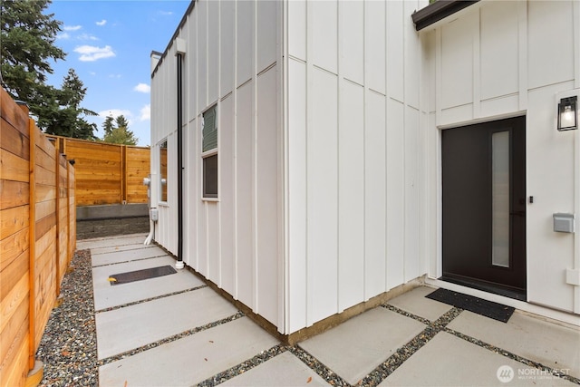 entrance to property with board and batten siding and fence