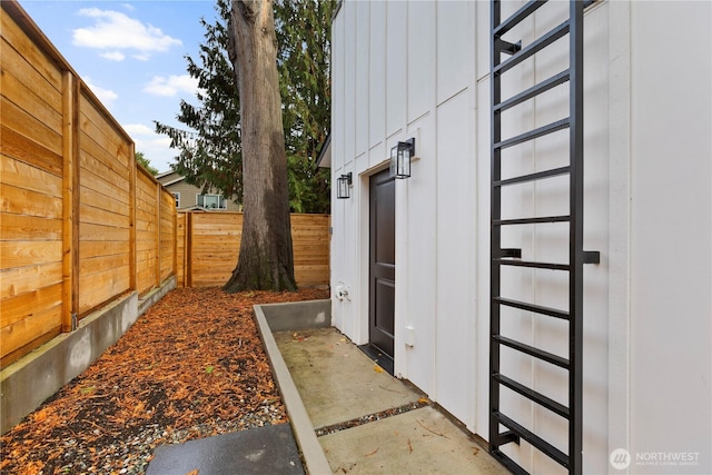 view of side of property with board and batten siding and fence private yard