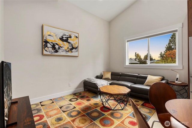 living room featuring lofted ceiling and baseboards