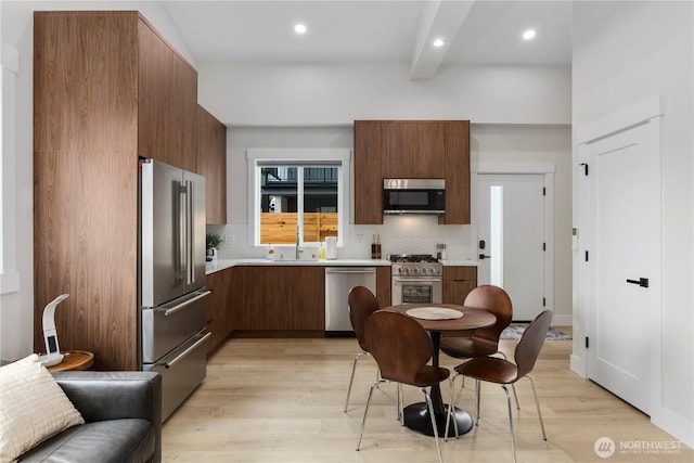 kitchen with light wood finished floors, modern cabinets, light countertops, and premium appliances