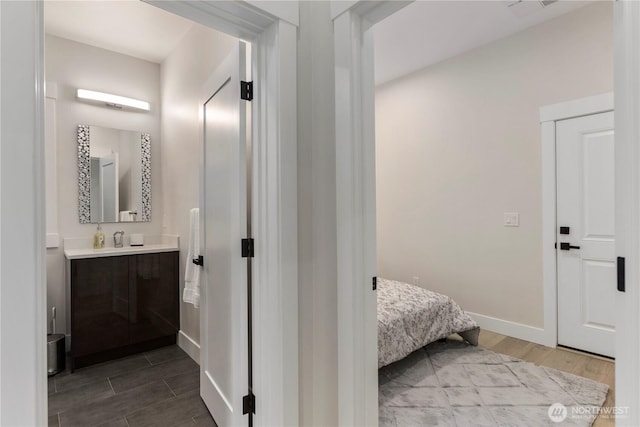 bathroom featuring visible vents, vanity, baseboards, and wood finish floors