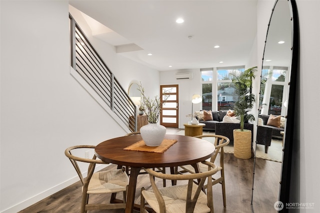 dining space featuring baseboards, a wall unit AC, stairway, dark wood-type flooring, and recessed lighting