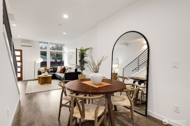 dining space with dark wood-style floors, stairway, a wall mounted AC, and recessed lighting