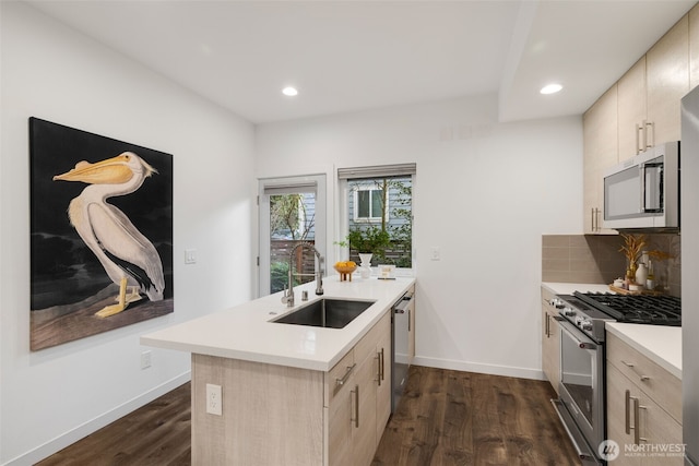 kitchen with light brown cabinets, light countertops, appliances with stainless steel finishes, and a sink