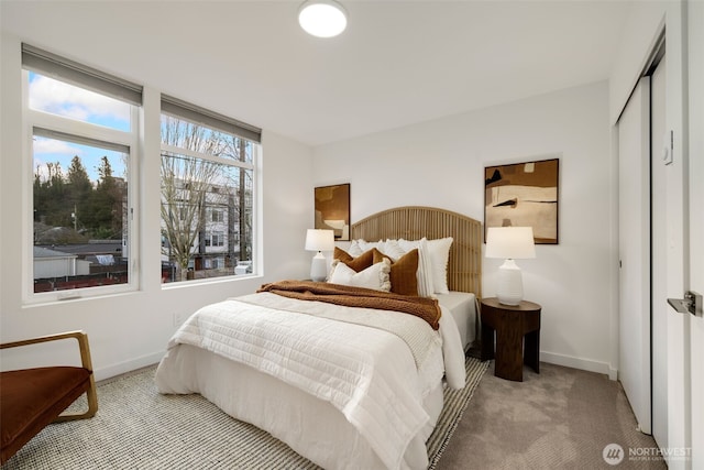 bedroom with light carpet, baseboards, and a closet