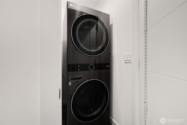 washroom featuring stacked washer and dryer and laundry area