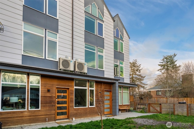 rear view of property with ac unit and fence