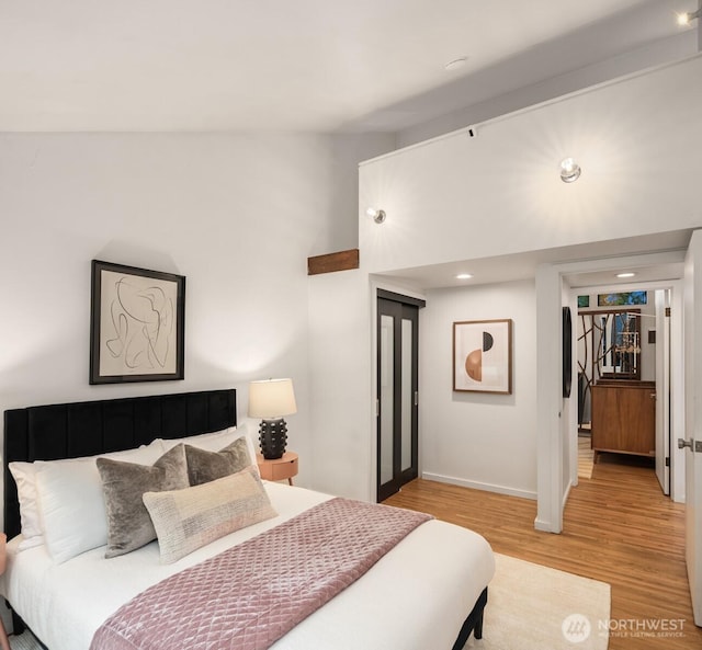 bedroom featuring light wood-type flooring, lofted ceiling, baseboards, and recessed lighting