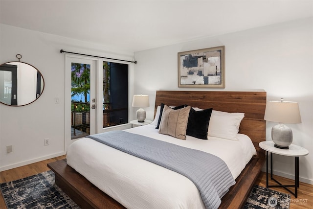 bedroom with dark wood-style floors, access to outside, and baseboards