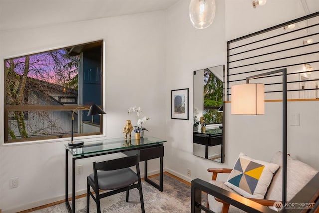 home office with baseboards and wood finished floors