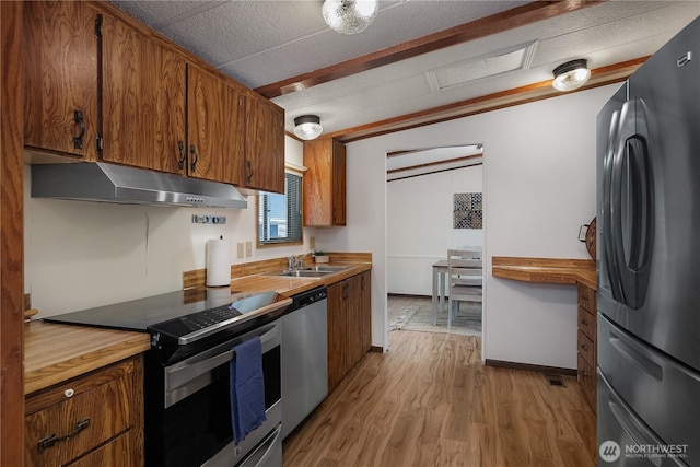 kitchen with light wood-type flooring, under cabinet range hood, electric range oven, freestanding refrigerator, and dishwasher