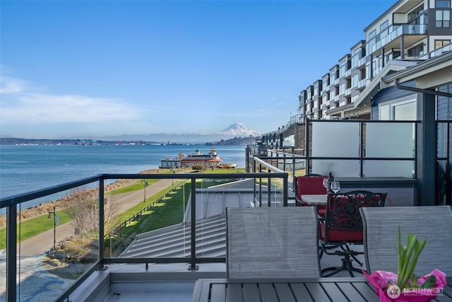 balcony featuring a water and mountain view