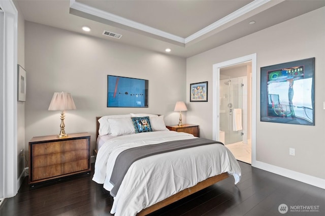 bedroom with a tray ceiling, crown molding, and wood finished floors