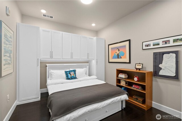 bedroom with dark wood-style floors, visible vents, baseboards, and recessed lighting