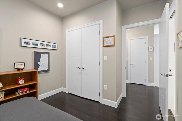 bedroom featuring a closet, recessed lighting, dark wood finished floors, and baseboards