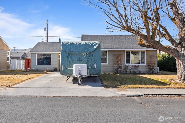 view of front of home with a shingled roof and a front lawn