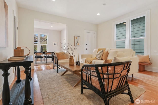 living room featuring baseboards, light wood-type flooring, and recessed lighting