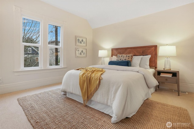 bedroom with lofted ceiling, light carpet, and baseboards