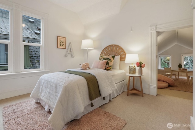 carpeted bedroom featuring lofted ceiling and baseboards