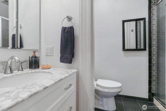 full bath featuring tile patterned floors, toilet, vanity, baseboards, and walk in shower