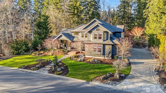 craftsman house featuring driveway and a front lawn