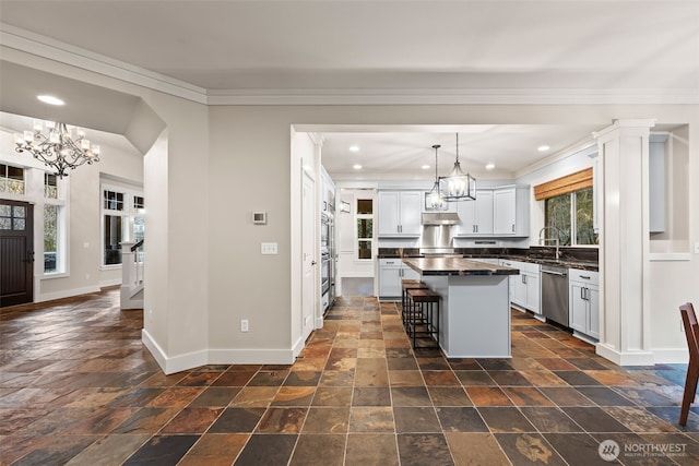 kitchen featuring dark countertops, baseboards, appliances with stainless steel finishes, and a chandelier