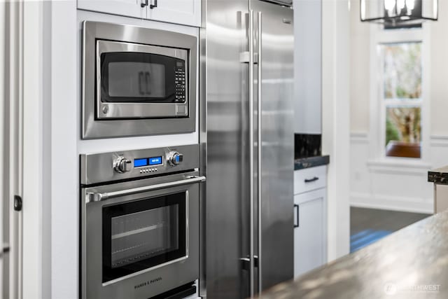 kitchen featuring stainless steel appliances and white cabinetry