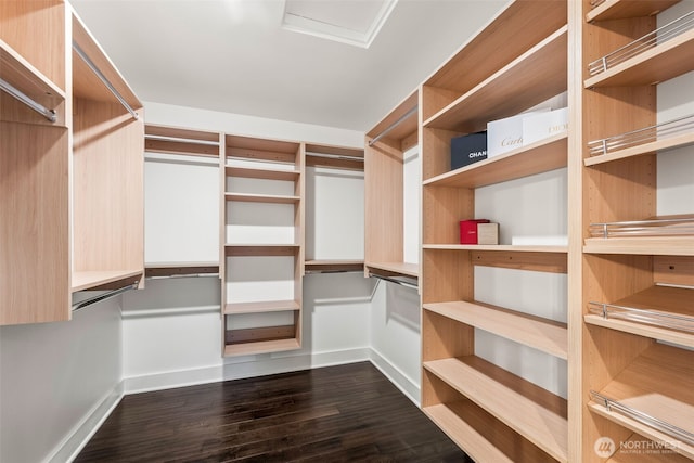 spacious closet with dark wood-type flooring and attic access