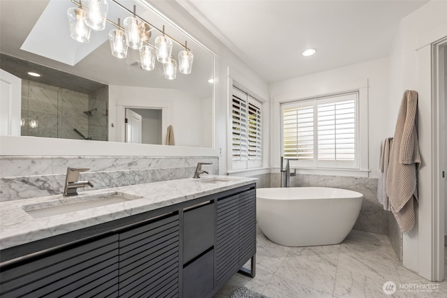 bathroom featuring double vanity, a soaking tub, marble finish floor, a shower stall, and a sink