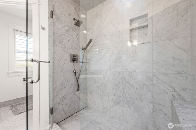 bathroom featuring a marble finish shower