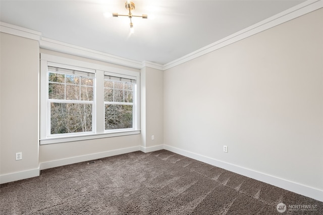 spare room with ornamental molding, visible vents, dark carpet, and baseboards