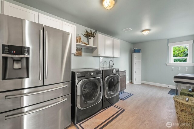 1831 Miracle Mile Dr E, Port Orchard, WA 98366 - clothes washing area with light wood finished floors, laundry area, baseboards, visible vents, and separate washer and dryer