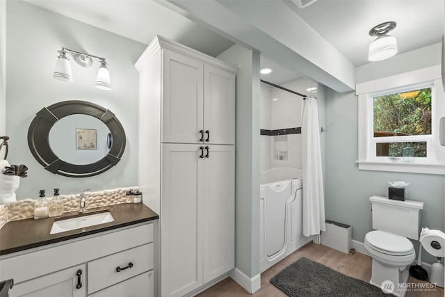 1831 Miracle Mile Dr E, Port Orchard, WA 98366 - bathroom with toilet, a shower with shower curtain, vanity, wood finished floors, and baseboards