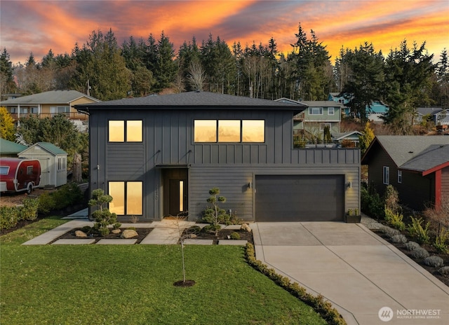 modern farmhouse style home featuring a garage, concrete driveway, board and batten siding, and a yard