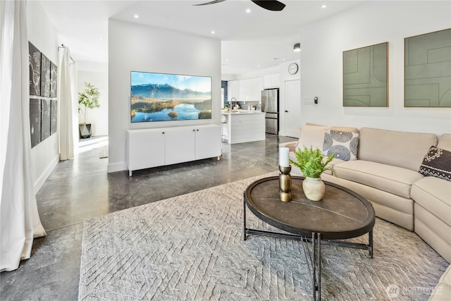 living room featuring ceiling fan, concrete floors, baseboards, and recessed lighting