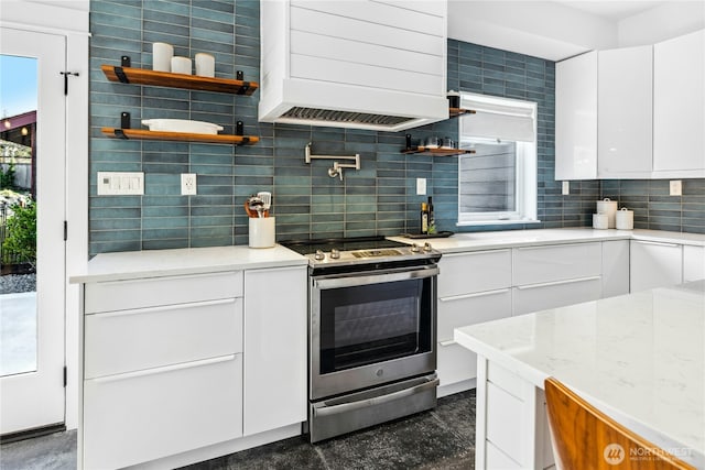 kitchen with premium range hood, white cabinets, decorative backsplash, stainless steel electric range oven, and open shelves