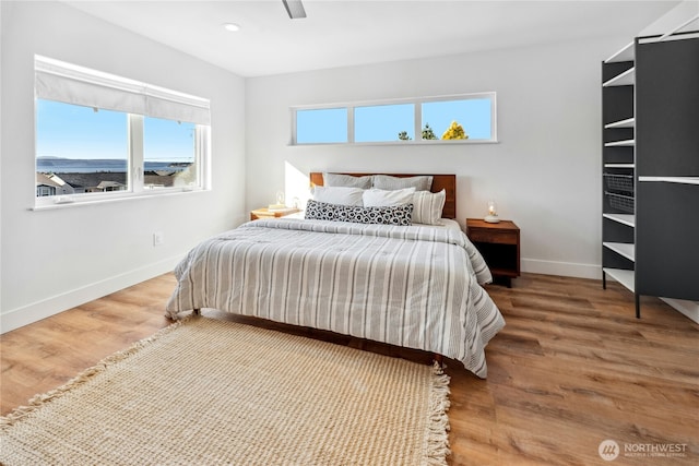 bedroom featuring baseboards, wood finished floors, and recessed lighting