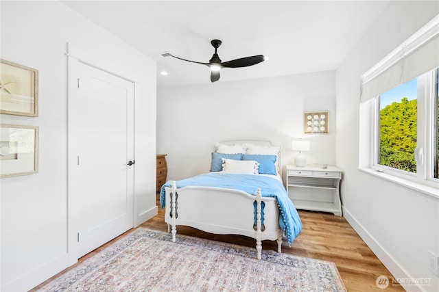 bedroom featuring ceiling fan, baseboards, and wood finished floors