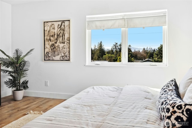 bedroom featuring baseboards and wood finished floors