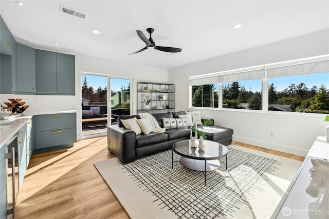 living room with recessed lighting, visible vents, and light wood finished floors