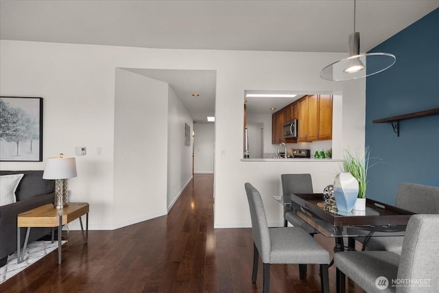 dining space featuring baseboards and dark wood-type flooring