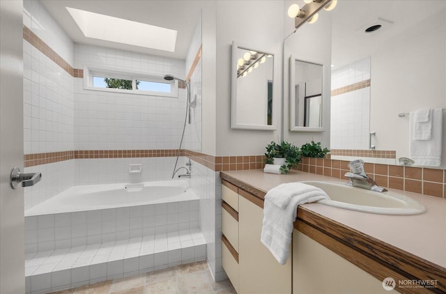 full bathroom with a skylight, tiled bath, tasteful backsplash, tiled shower, and vanity