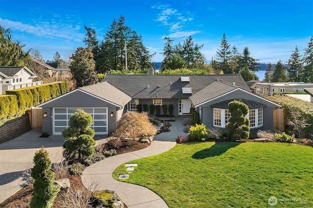 ranch-style home with a garage, concrete driveway, a front lawn, and fence