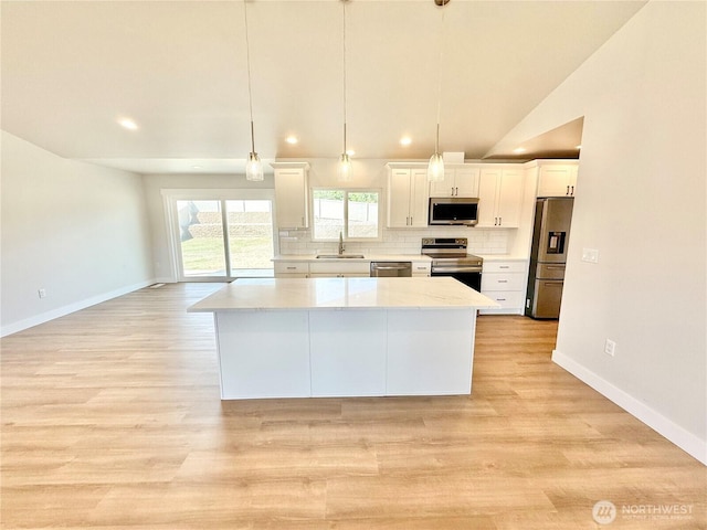 2575 1st St SE, East Wenatchee, WA 98802 - kitchen featuring stainless steel appliances, white cabinets, a kitchen island, backsplash, and light wood-style floors