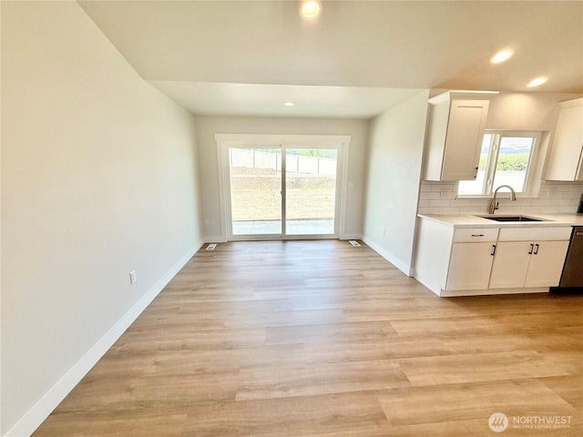 2575 1st St SE, East Wenatchee, WA 98802 - kitchen featuring light countertops, white cabinetry, backsplash, recessed lighting, and light wood-style flooring