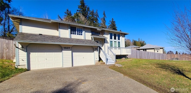 view of front facade featuring a garage, concrete driveway, a front yard, and fence